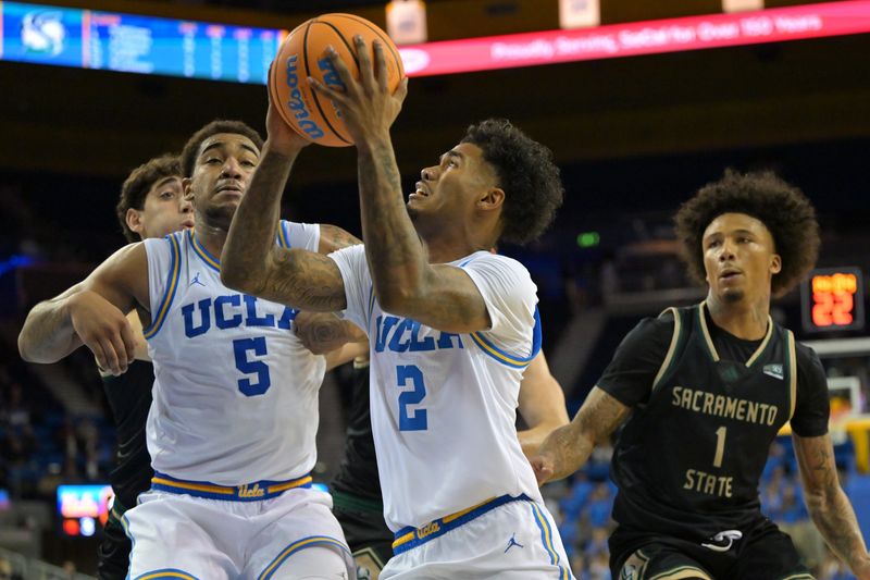 Nov 18, 2025; Los Angeles, California, USA; UCLA Bruins guard Donovan Dent (2) scores past Sacramento State Hornets guard Mikey Williams (1) during the second half at Pauley Pavilion presented by Wescom Financial. Mandatory Credit: Jayne Kamin-Oncea-Imagn Images
