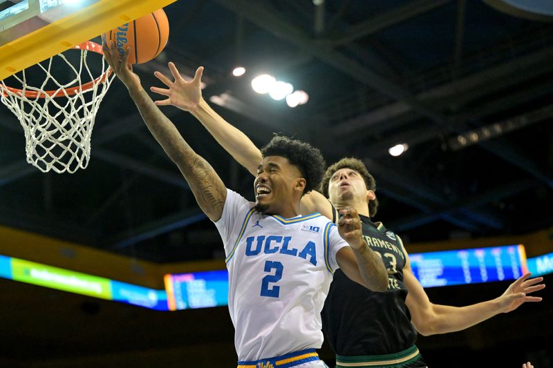 Nov 18, 2025; Los Angeles, California, USA; UCLA Bruins guard Donovan Dent (2) scores past Sacramento State Hornets guard Arman Madi (23) during the second half at Pauley Pavilion presented by Wescom Financial. Mandatory Credit: Jayne Kamin-Oncea-Imagn Images