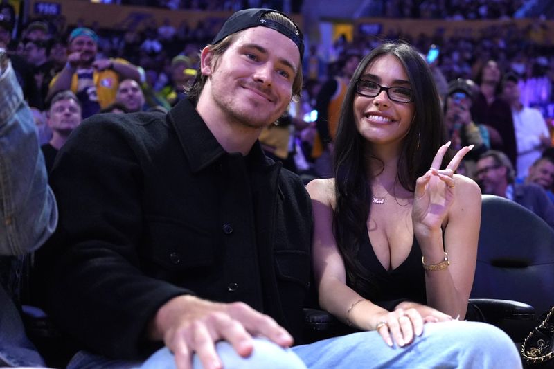 Oct 24, 2025; Los Angeles, California, USA; Los Angeles Chargers quarterback Justin Herbert (left) and girlfriend Madison Beer attend the game between the Minnesota Timberwolves and the Los Angeles Lakers at Crypto.com Arena. Mandatory Credit: Kirby Lee-Imagn Images