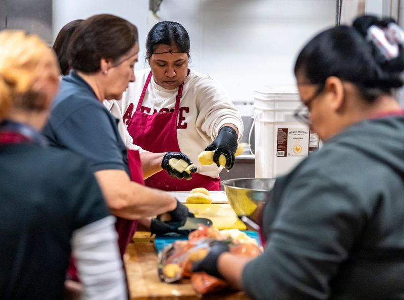 Volunteer Patty Mora of Indio helps a crew of women prepare 240 pounds of potatoes for a Thanksgiving feast at the Coachella Valley Rescue Mission in Indio, Calif., Thursday, Nov. 27, 2025.
