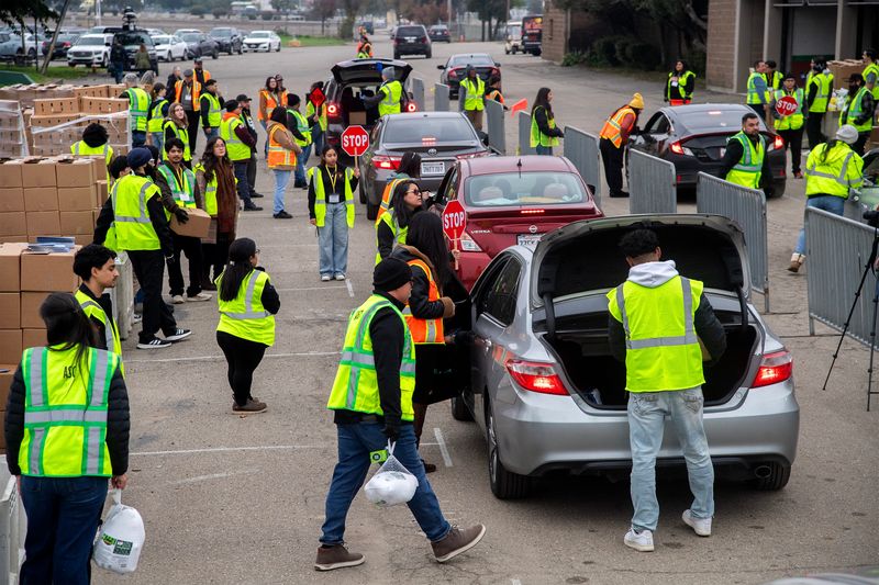 Volunteers load turkeys and Thanksgiving food boxes into vehicles during the Stockton/San Joaquin Emergency Food Bank’s annual Turkey Box giveaway at the San Joaquin County Fairgrounds in Stockton on Nov. 25, 2025. About 45 volunteers gave out about 2,200 frozen turkeys and food boxes to the needy in the drive-up event.