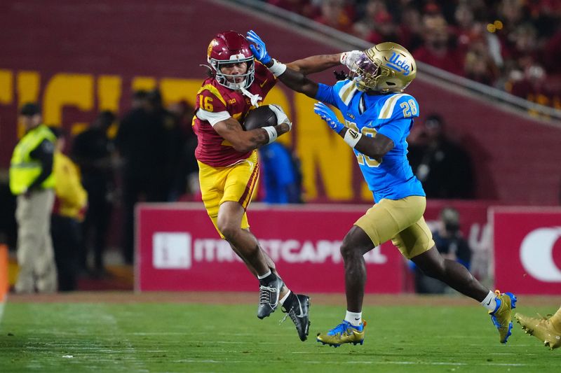 Nov 29, 2025; Los Angeles, California, USA; Southern California Trojans wide receiver Tanook Hines (16) carries the ball against UCLA Bruins defensive back Scooter Jackson (28) in the first half at United Airlines Field at Los Angeles Memorial Coliseum. Mandatory Credit: Kirby Lee-Imagn Images