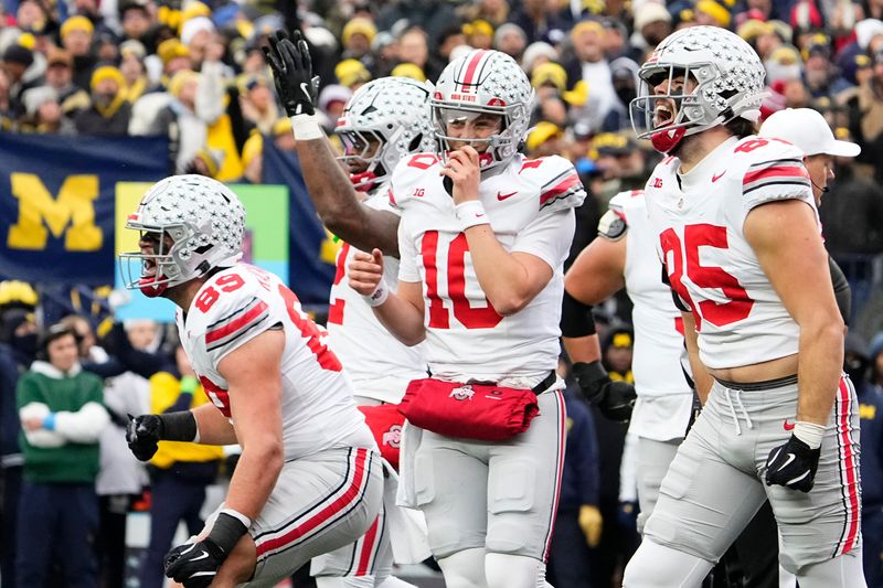 Ohio State Buckeyes tight end Will Kacmarek (89), running back CJ Donaldson Jr. (12), quarterback Julian Sayin (10) and tight end Bennett Christian (85) celebrate during the NCAA football game against the Michigan Wolverines at Michigan Stadium in Ann Arbor, Mich. on Nov. 29, 2025. Ohio State won 27-9.