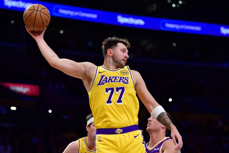 Dec 1, 2025; Los Angeles, California, USA; Los Angeles Lakers guard Luka Doncic (77) gets the rebound against the against the Phoenix Suns during the first half at Crypto.com Arena. Mandatory Credit: Gary A. Vasquez-Imagn Images
