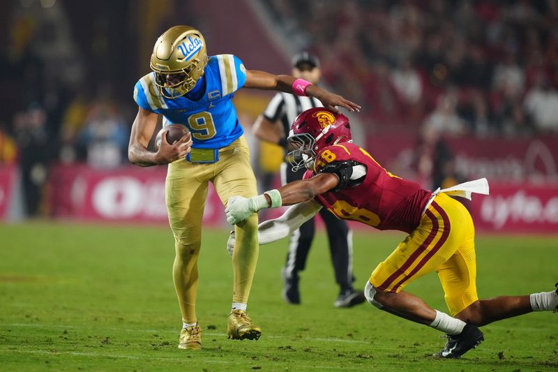 Nov 29, 2025; Los Angeles, California, USA; UCLA Bruins quarterback Nico Iamaleava (9) is tackled by Southern California Trojans linebacker Eric Gentry (18) in the second half at United Airlines Field at Los Angeles Memorial Coliseum. Mandatory Credit: Kirby Lee-Imagn Images
