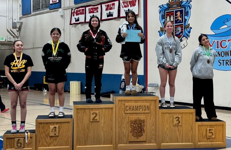 Tokay wrestler Zoe Mireles, holding the blue bracket sheet, stands atop the podium as the champion at the Lady Royal Tournament at Overfelt High School on Dec. 6.