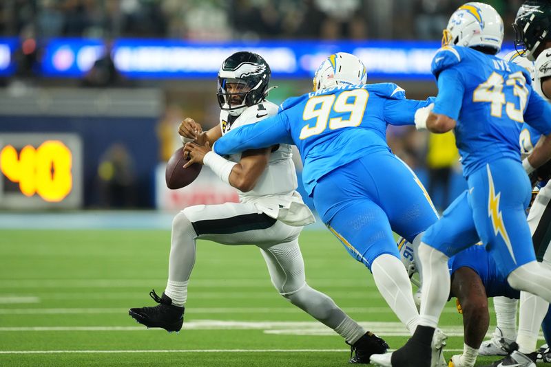 Dec 8, 2025; Inglewood, California, USA; Los Angeles Chargers defensive tackle Jamaree Caldwell (99) tackles Philadelphia Eagles quarterback Jalen Hurts (1) in the first half at SoFi Stadium. Mandatory Credit: Kirby Lee-Imagn Images