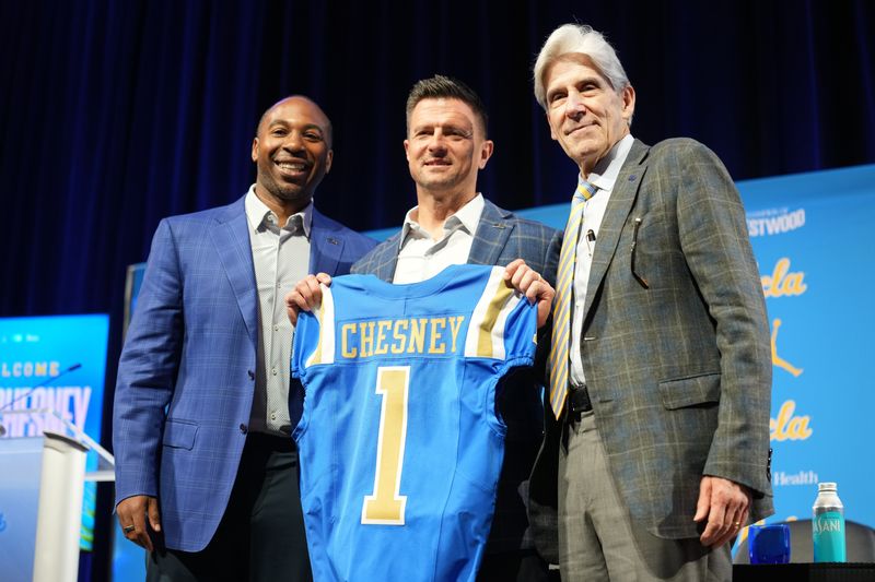 UCLA Bruins football coach Bob Chesney (center) poses with athletic director Martin Jarmond (left) and chancellor Julio Frenk at introductory press conference at Renee Luskin Conference Center Centennial Ballroom on Tuesday, Dec. 9, 2025.