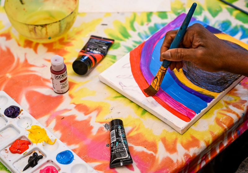 A woman works with acrylic paint during a session at My Voice Media Center on Thursday, December 11, 2025.