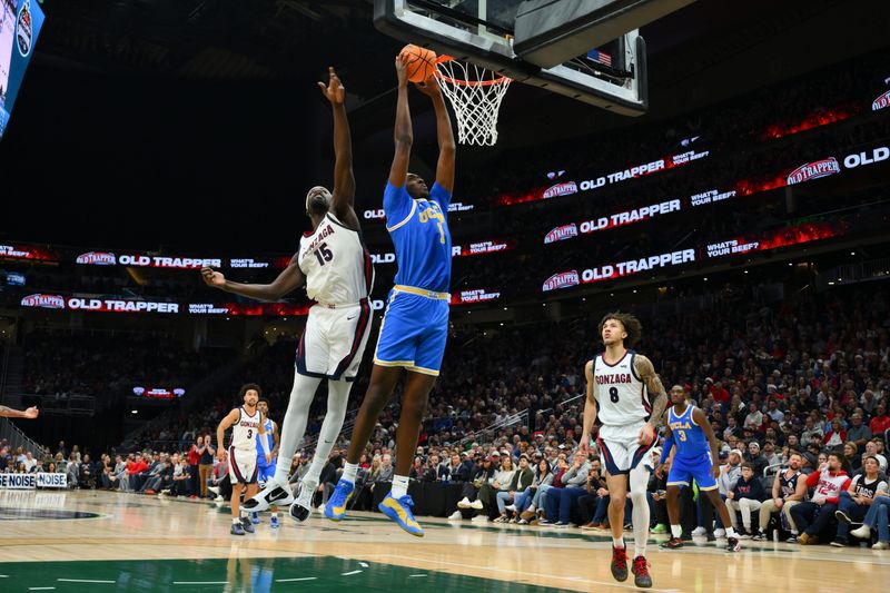Dec 13, 2025; Seattle, Washington, USA; UCLA Bruins center Xavier Booker (1) dunks the ball while guarded by Gonzaga Bulldogs forward Graham Ike (15) during the second half at Climate Pledge Arena. Mandatory Credit: Steven Bisig-Imagn Images