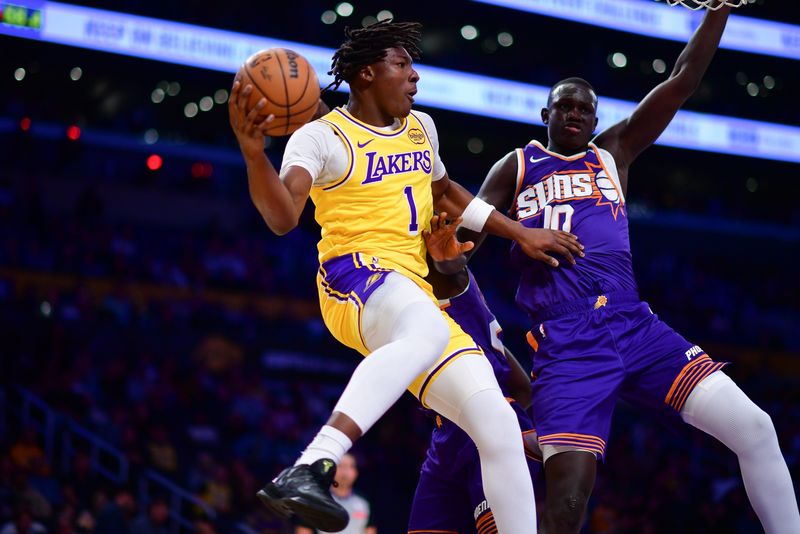 Dec 1, 2025; Los Angeles, California, USA; Los Angeles Lakers forward Adou Thiero (1) passes the ball against Phoenix Suns center Khaman Maluach (10) during the second half at Crypto.com Arena. Mandatory Credit: Gary A. Vasquez-Imagn Images