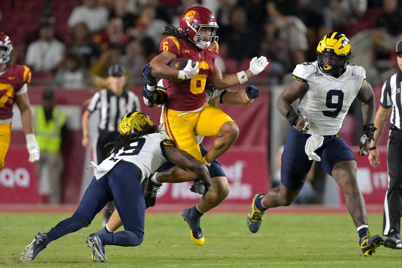 Oct 11, 2025; Los Angeles, California, USA; USC Trojans wide receiver Makai Lemon (6) runs for a first down before he is stopped by Michigan Wolverines linebacker Jimmy Rolder (30), defensive back Rod Moore (19) and defensive end Cameron Brandt (9) in the second half at United Airlines Field at the Los Angeles Memorial Coliseum. Mandatory Credit: Jayne Kamin-Oncea-Imagn Images