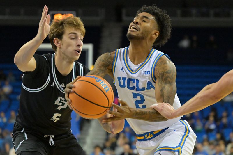 Dec 19, 2025; Los Angeles, California, USA; UCLA Bruins guard Donovan Dent (2) is defended by Cal Poly Mustangs guard Guzman Vasilic (5) as he drives to the basket during the first half at Pauley Pavilion presented by Wescom Financial. Mandatory Credit: Jayne Kamin-Oncea-Imagn Images