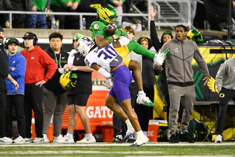Dec 20, 2025; Eugene, OR, USA; Oregon Ducks wide receiver Jeremiah McClellan (11) attempts to make a catch over James Madison Dukes cornerback Justin Eaglin (30) during the second quarter at Autzen Stadium. Mandatory Credit: Troy Wayrynen-Imagn Images