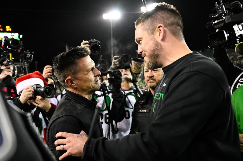 James Madison Dukes head coach Bob Chesney and Oregon Ducks head coach Dan Lanning greet one another after the game at Autzen Stadium.