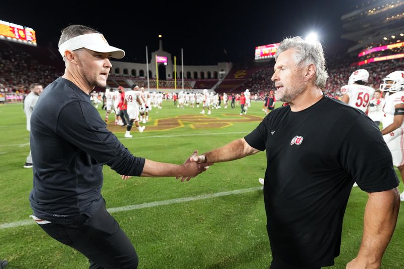 Oct 21, 2023; Los Angeles, California, USA; Utah Utes head coach Kyle Whittingham shakes hands with Southern California Trojans head coach Lincoln Riley after the game at United Airlines Field at Los Angeles Memorial Coliseum. Mandatory Credit: Kirby Lee-USA TODAY Sports