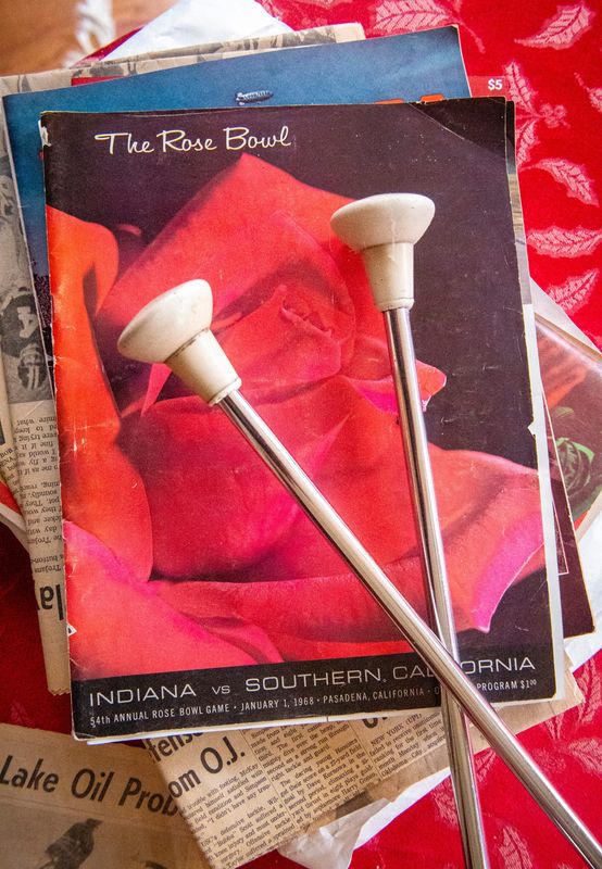 The batons Larry Lafferty used during the 1968 Rose Bowl game rest on a game program from the 1968 Rose Bowl game on his table in his home on Tuesday, Dec. 23, 2025.