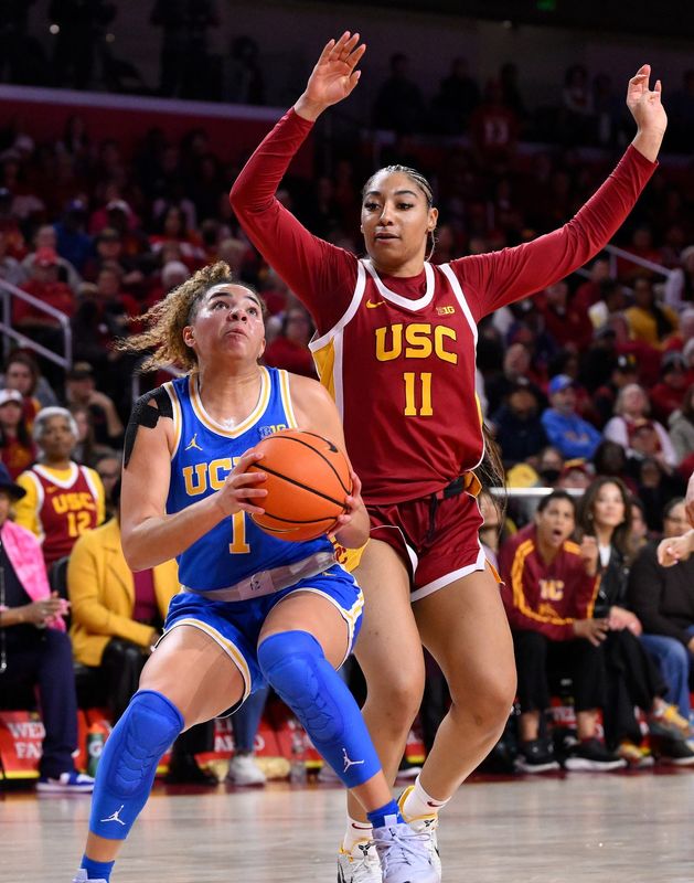 Feb 13, 2025; Los Angeles, California, USA; UCLA Bruins guard Kiki Rice (1) and USC Trojans guard Kennedy Smith (11) during an NCAA basketball game at Galen Center. Mandatory Credit: Robert Hanashiro-Imagn Images