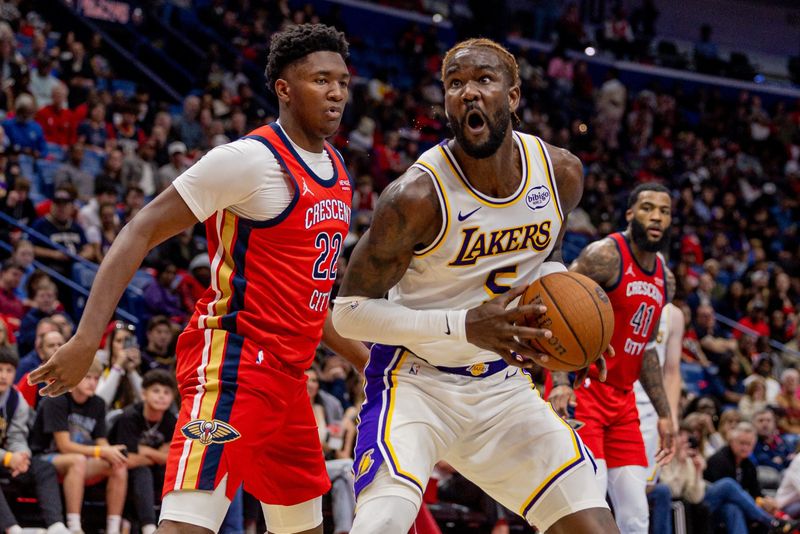 Nov 14, 2025; New Orleans, Louisiana, USA; Los Angeles Lakers center Deandre Ayton (5) dribbles against New Orleans Pelicans center Derik Queen (22) during the first half at Smoothie King Center. Mandatory Credit: Stephen Lew-Imagn Images