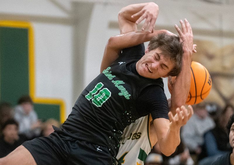 St. Mary’s Mason Eagal, front, fights for a round with Tracy’s Gabriel Canalita during a boys varsity basketball game at Tracy High School in Tracy on Jan. 7, 2025. Tracy won 61-59.