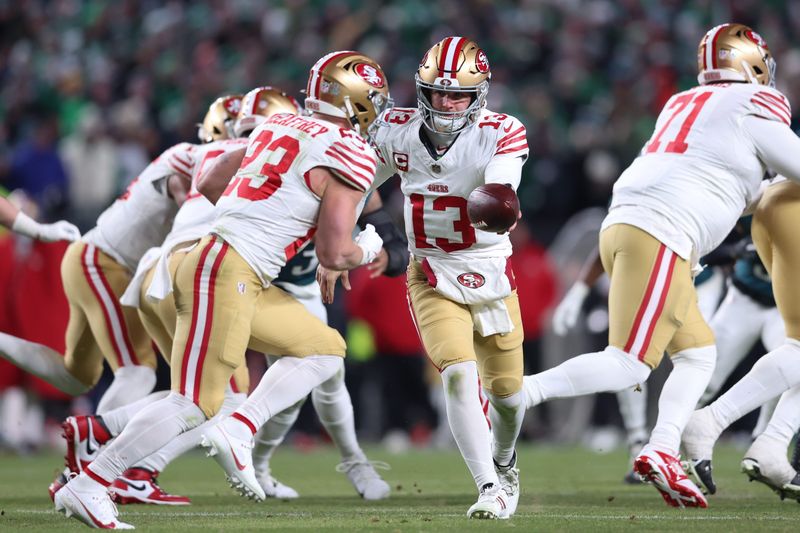 Jan 11, 2026; Philadelphia, PA, USA; San Francisco 49ers quarterback Brock Purdy (13) hands off the ball to running back Christian McCaffrey (23) against the Philadelphia Eagles during the second quarter in an NFC Wild Card Round game at Lincoln Financial Field.