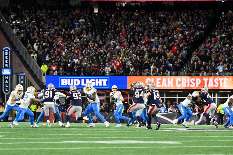 Jan 11, 2026; Foxborough, MA, USA; Los Angeles Chargers quarterback Justin Herbert (10) scrambles out of the pocket during the second half against the New England Patriots in an AFC Wild Card Round game at Gillette Stadium. Mandatory Credit: Eric Canha-Imagn Images