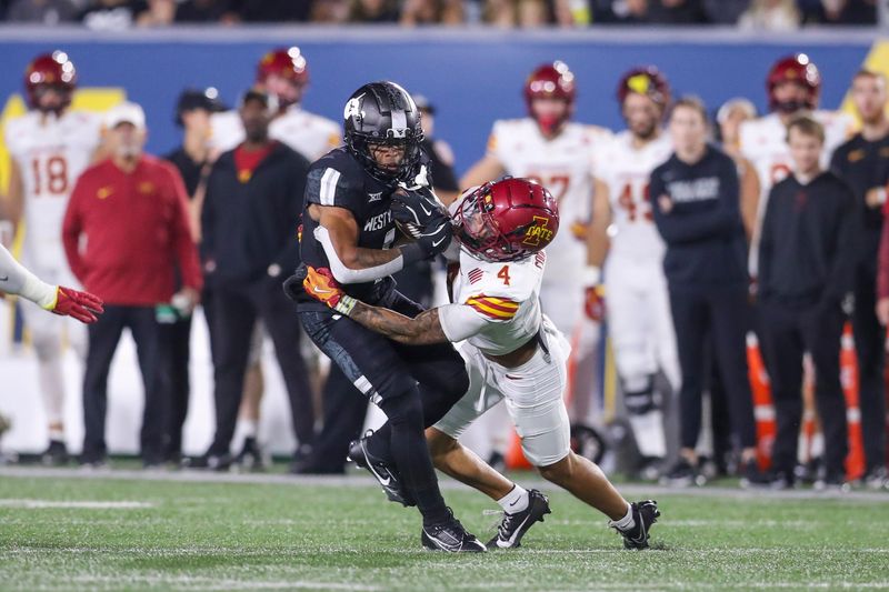 Oct 12, 2024; Morgantown, West Virginia, USA; West Virginia Mountaineers running back Jahiem White (1) runs the ball and is tackled by Iowa State Cyclones defensive back Jeremiah Cooper (4) during the first quarter at Mountaineer Field at Milan Puskar Stadium. Mandatory Credit: Ben Queen-Imagn Images