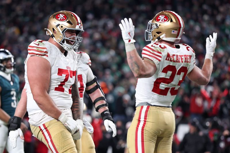 Jan 11, 2026; Philadelphia, PA, USA; San Francisco 49ers running back Christian McCaffrey (23) celebrates after scoring a touchdown against the Philadelphia Eagles with San Francisco 49ers guard Dominick Puni (77) during the fourth quarter in an NFC Wild Card Round game at Lincoln Financial Field. Mandatory Credit: Bill Streicher-Imagn Images