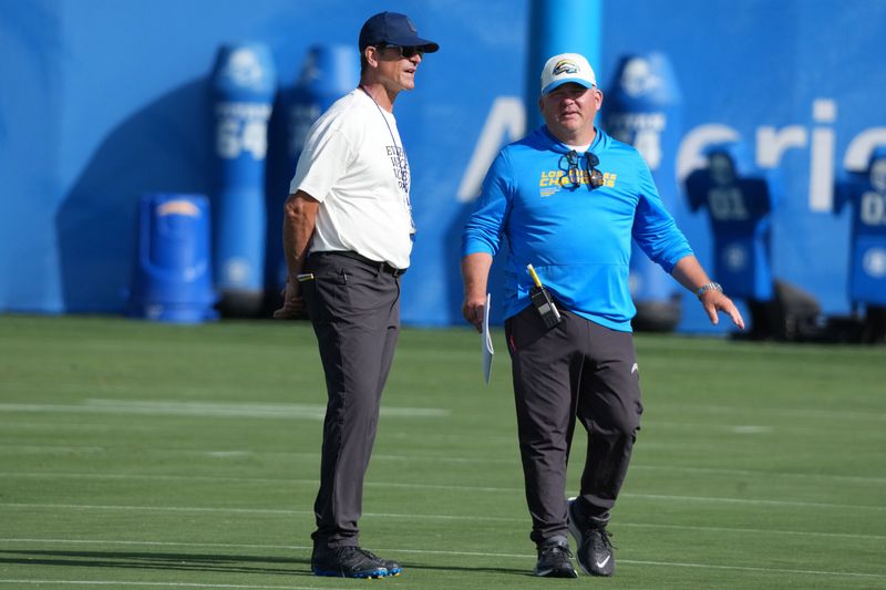aJul 25, 2025; El Segundo, CA, USA; Los Angeles Chargers coach Jim Harbaugh (left) and offensive coordinator Greg Roman during training camp at The Bolt. Mandatory Credit: Kirby Lee-Imagn Images