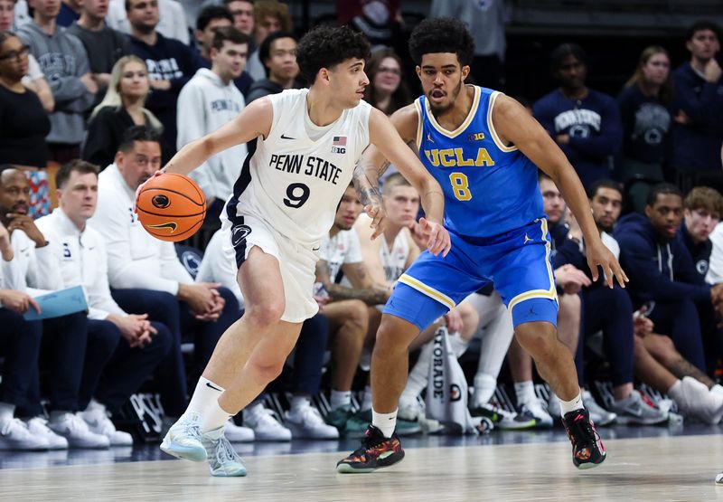 Jan 14, 2026; University Park, Pennsylvania, USA; Penn State Nittany Lions guard Melih Tunca (9) dribbles the ball around the outside of UCLA Bruins guard Eric Freeny (8) during the second half at Bryce Jordan Center. Mandatory Credit: Matthew O'Haren-Imagn Images