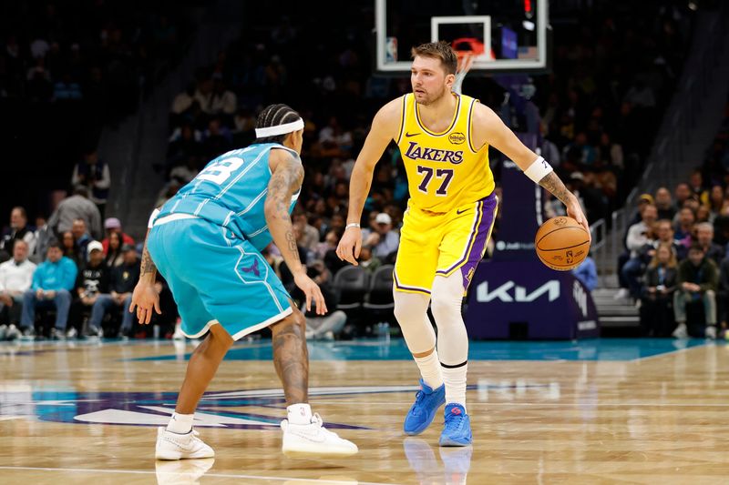 Nov 10, 2025; Charlotte, North Carolina, USA; Los Angeles Lakers forward/guard Luka Doncic (77) is guarded by Charlotte Hornets guard Tre Mann (23) during the second quarter at Spectrum Center. Mandatory Credit: Brian Westerholt-Imagn Images