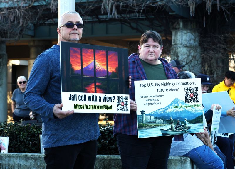David Duke, left, and Katrinia Baumann holds signs opposing a proposed alternative custody campus and possible jail next to their south Redding neighborhood. “There’s got to be a safer place to put a jail and inmates than next to a residential area,” Duke said.