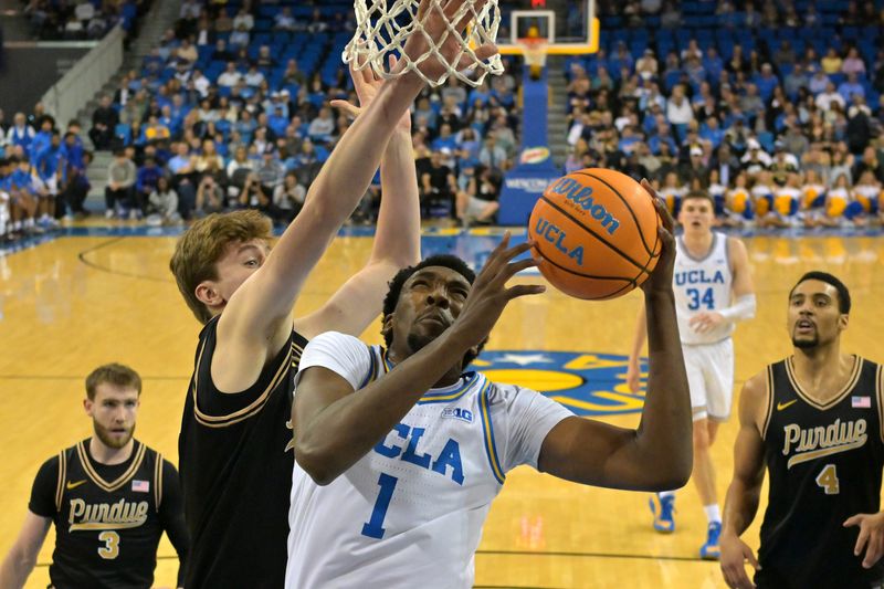 Jan 20, 2026; Los Angeles, California, USA; UCLA Bruins forward Xavier Booker (1) drives ast Purdue Boilermakers center Daniel Jacobsen (12) in the first half at Pauley Pavilion presented by Wescom Financial. Mandatory Credit: Jayne Kamin-Oncea-Imagn Images