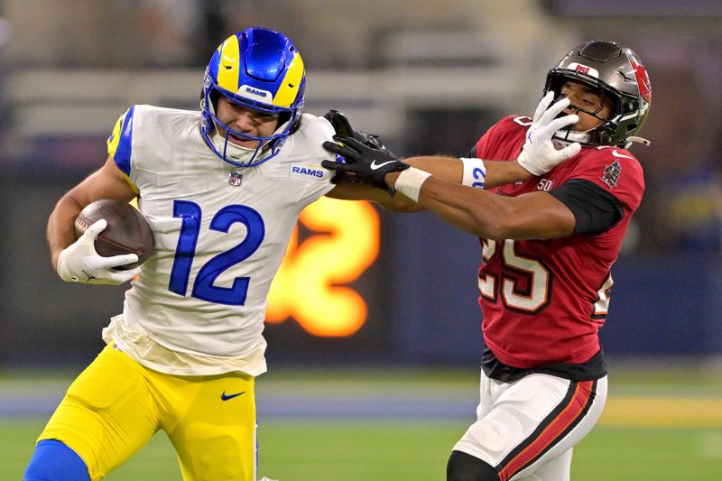 Nov 23, 2025; Inglewood, California, USA; Los Angeles Rams wide receiver Puka Nacua (12) stiff arms Tampa Bay Buccaneers cornerback Jacob Parrish (25) as he runs for a first down at SoFi Stadium. Mandatory Credit: Jayne Kamin-Oncea-Imagn Images
