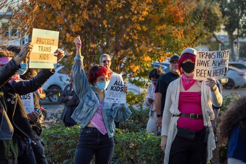 Transgender athlete supporters hold up signs outside of the Riverside Unified School District meeting to debate the rights of transgender athletes to compete in high school sports in Riverside, on Dec. 19, 2024.