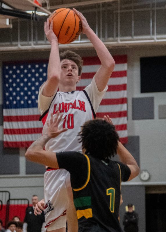 Lincoln’s Harper Matthews, left, shoots over Tracy’s Cam Breckenridge during a boys varsity basketball game at Lincoln in Stockton on Jan. 23, 2026. Lincoln won 68-30.