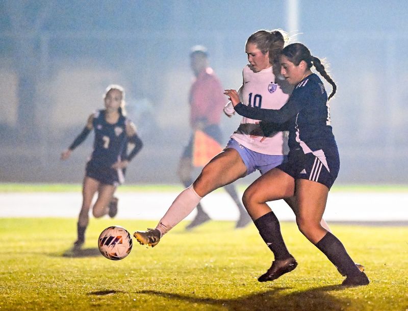 El Diamante's Aubrie Del Rio, right, and Redwood’s Avery Yagle battle in East Yosemite League high school girls soccer Friday, January 23, 2026.
