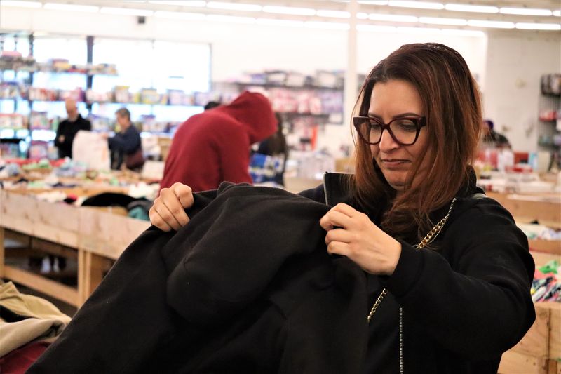 Monica Virgin examines a jacket for purchase at Victorville's new discount bin store, located at 14790 La Paz Dr.