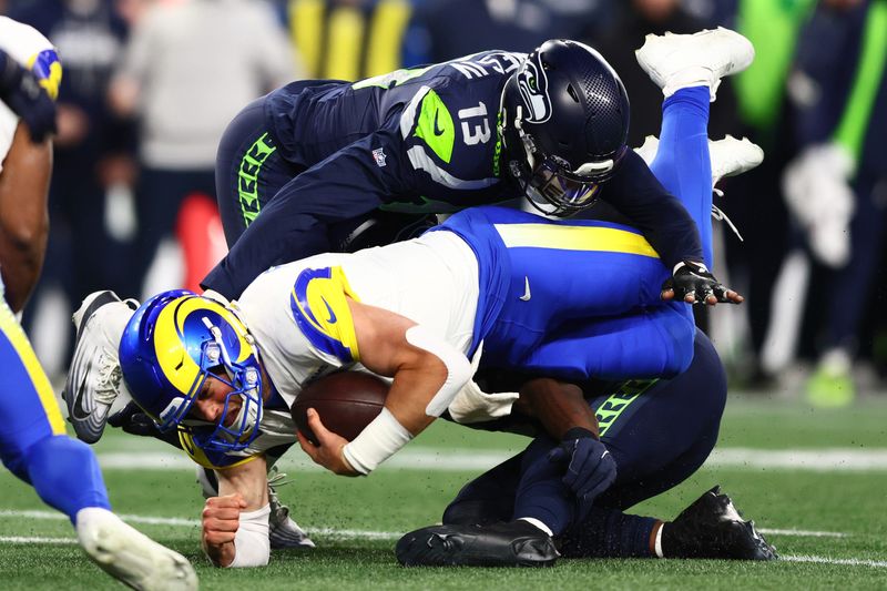 Jan 25, 2026; Seattle, WA, USA; Los Angeles Rams quarterback Matthew Stafford (9) dives for a first down against Seattle Seahawks linebacker Ernest Jones IV (13) during the second half in the 2026 NFC Championship Game at Lumen Field. Mandatory Credit: Kevin Ng-Imagn Images
