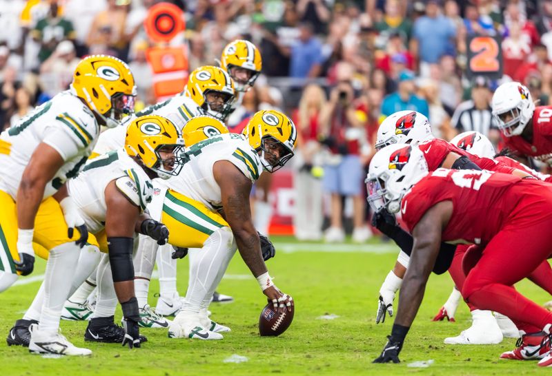 Oct 19, 2025; Glendale, Arizona, USA; General view down the line of scrimmage as Green Bay Packers center Elgton Jenkins (74) prepares to snap the ball against the Arizona Cardinals at State Farm Stadium. Mandatory Credit: Mark J. Rebilas-Imagn Images