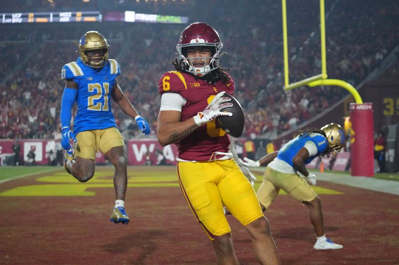 Nov 29, 2025; Los Angeles, California, USA; Southern California Trojans wide receiver Makai Lemon (6) catches a 32-yard touchdown pass against UCLA Bruins defensive back Kanye Clark (1) in the second half at United Airlines Field at Los Angeles Memorial Coliseum. Mandatory Credit: Kirby Lee-Imagn Images