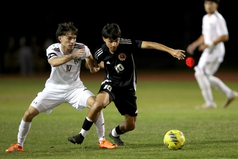 Rancho Mirage middle fielder Ely Villa (10), left, and Palm Desert middle fielder Andres Chaparro (10) battle for the ball in Palm Desert, Calif., on Tuesday, Feb. 3, 2026.