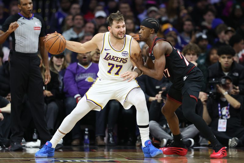 Dec 7, 2025; Philadelphia, Pennsylvania, USA; Los Angeles Lakers guard Luka Doncic (77) controls the ball against Philadelphia 76ers guard Vj Edgecombe (77) during the third quarter at Xfinity Mobile Arena. Mandatory Credit: Bill Streicher-Imagn Images