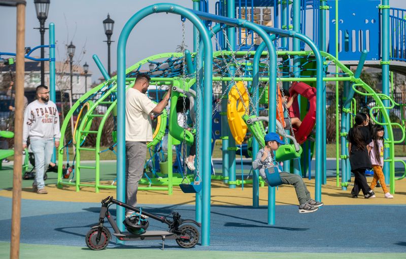 Children and parents play on playground equipment during a dedication ceremony for Inspiration Park in north Stockton on Stockton on Feb. 7, 2026. The 12-acre park was dedicated to Stockton Police Officer Jimmy Inn and Stockton Fire Captain Vidal “Max” Fortuna. Inn was killed while responding to a domestic dispute in 2021 and Fortuna was killed while working a fire in 2022.