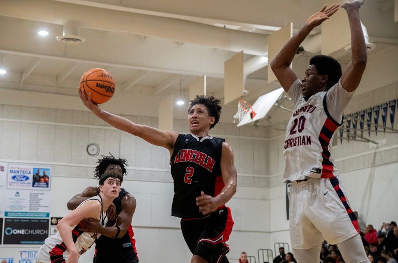 Lincoln’s Tre Simmons, left, goes to the hoop against Modesto Christian’s Somto Patrick during a boys varsity basketball game at Modesto Christian High School in Modesto on Feb. 4, 2026. Modesto Christian won 57 to 56.