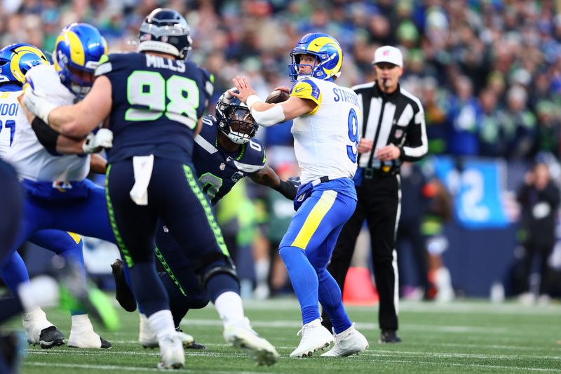Jan 25, 2026; Seattle, WA, USA; Los Angeles Rams quarterback Matthew Stafford (9) passes against Seattle Seahawks defensive end DeMarcus Lawrence (0) during the first half in the 2026 NFC Championship Game at Lumen Field. Mandatory Credit: Kevin Ng-Imagn Images
