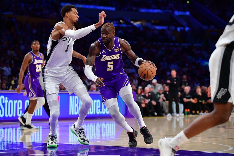 Nov 5, 2025; Los Angeles, California, USA; Los Angeles Lakers center Deandre Ayton (5) moves to the basket against San Antonio Spurs forward Victor Wembanyama (1) during the first half at Crypto.com Arena. Mandatory Credit: Gary A. Vasquez-Imagn Images