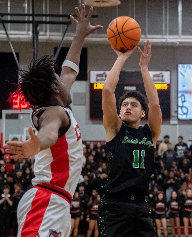St. Mary’s Kona Gomez, right, shoots over Lincoln’s Semaj Bluford during a boys varsity basketball game at Lincoln High School in Stockton on Feb. 13, 2026. Lincoln won 69-25.