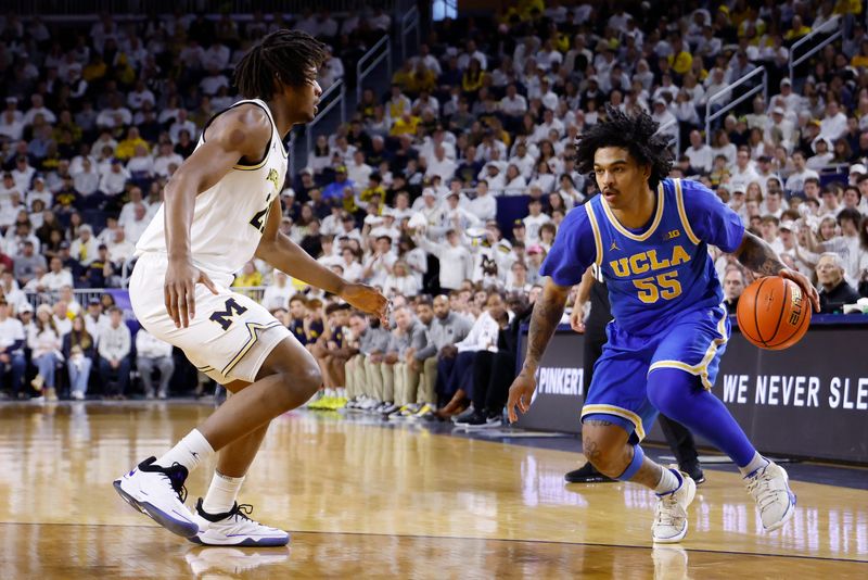 Feb 14, 2026; Ann Arbor, Michigan, USA; UCLA Bruins guard Skyy Clark (55) dribbles defended by Michigan Wolverines forward Morez Johnson Jr. (21) in the second half at Crisler Center. Mandatory Credit: Rick Osentoski-Imagn Images
