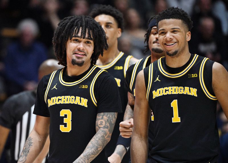Michigan Wolverines guard Elliot Cadeau (3) shares a moment with Michigan Wolverines guard Trey McKenney (1) during the second half against the Purdue Boilermakers at Mackey Arena in West Lafayette, Indiana, on Tuesday, Feb. 17, 2026.